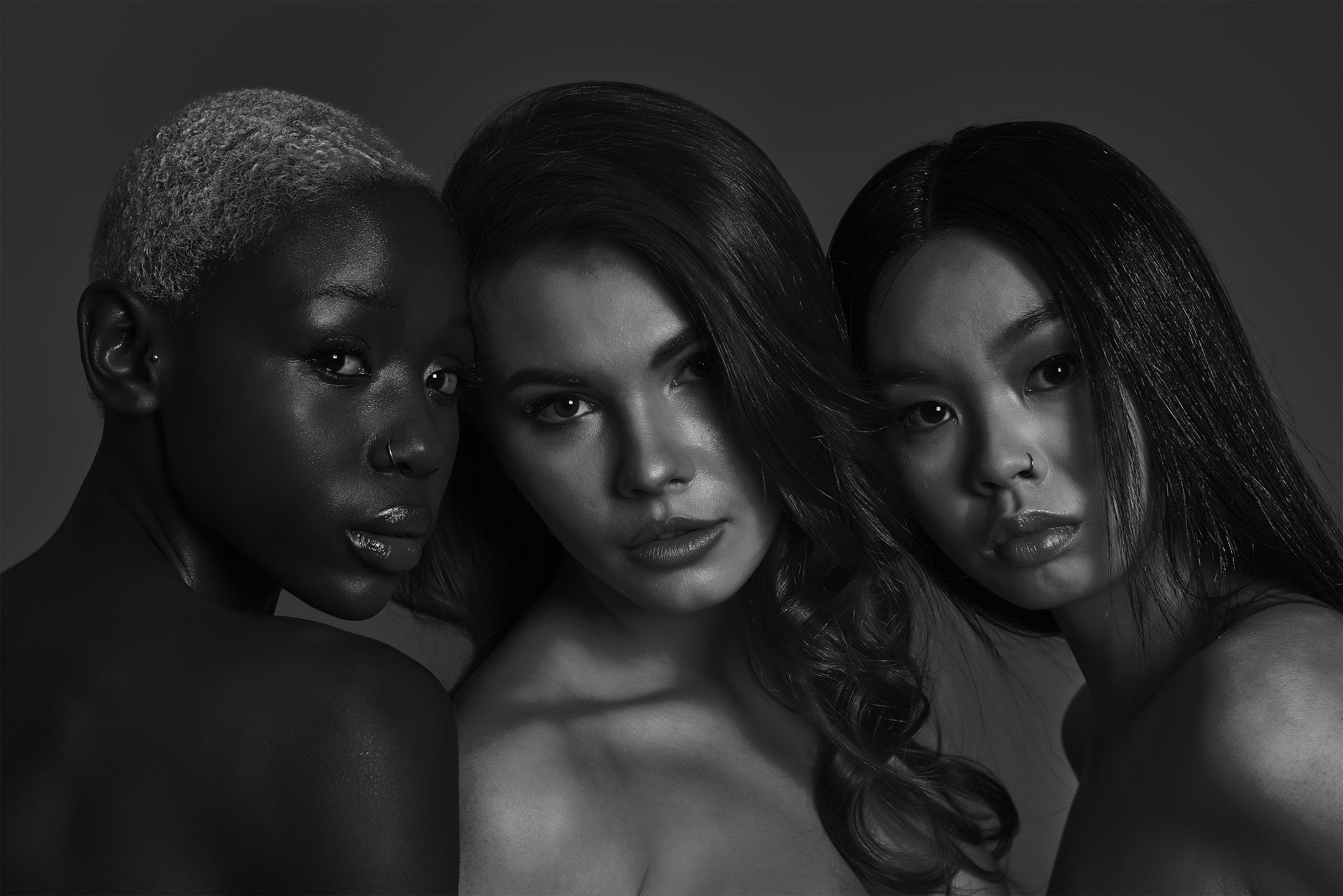 Editorial black-and-white portrait of three models (not JAG patients or staff)